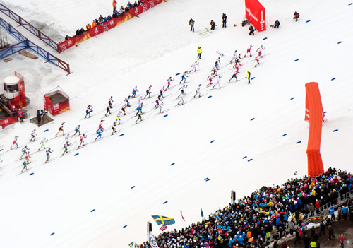 Aerial view of a cross-country ski race in Falun, with a pack of skiers and spectators along the course