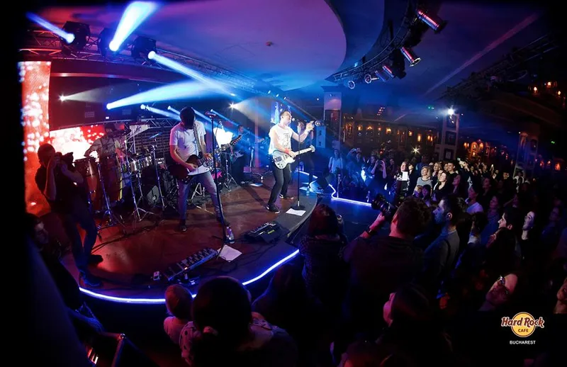 Band performing on the Hard Rock Cafe Bucharest stage under blue light beams, audience in front