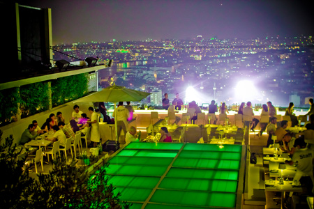 Nu Teras rooftop terrace at night, with diners, a lit glass floor and the Istanbul skyline