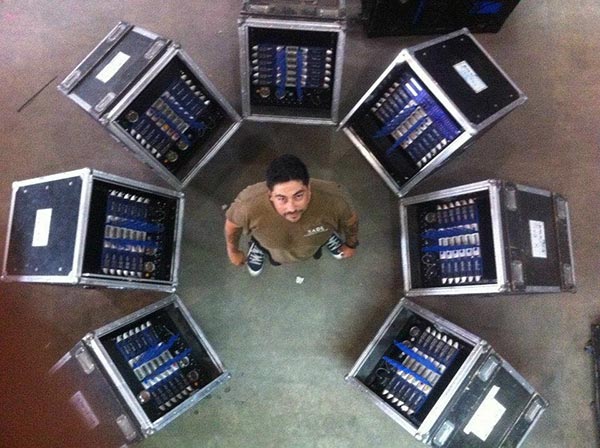 Overhead view of a technician standing inside a circle of open amplifier racks