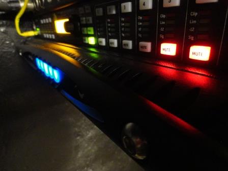 Close-up of a Powersoft X4 front panel below a processor with lit mute buttons