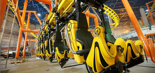 Yellow roller coaster cars on an orange track at the Galaxy indoor amusement park
