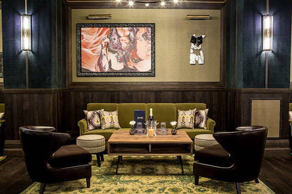 Lounge at The Oxford Social Club with a green sofa and leather armchairs