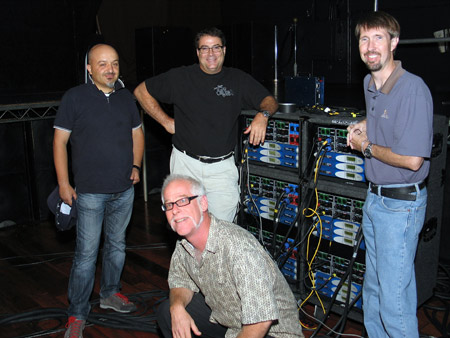 Four men beside racks of Powersoft K Series amplifiers