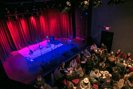Isis Restaurant and Music Hall from above: stage with red curtains and instruments, diners at tables