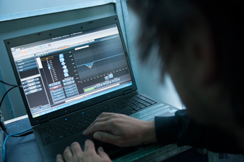 Technician adjusting an equalizer curve in Powersoft Armonía software on a laptop