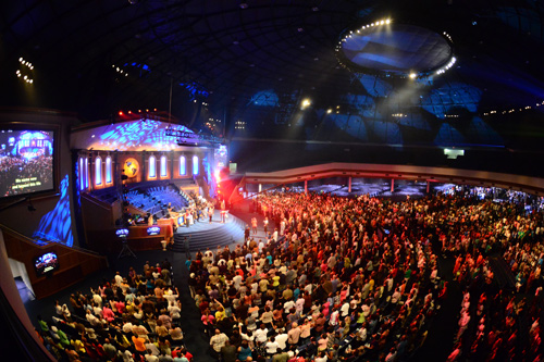 Congregation filling the World Changers Church sanctuary, facing the stage and video screens