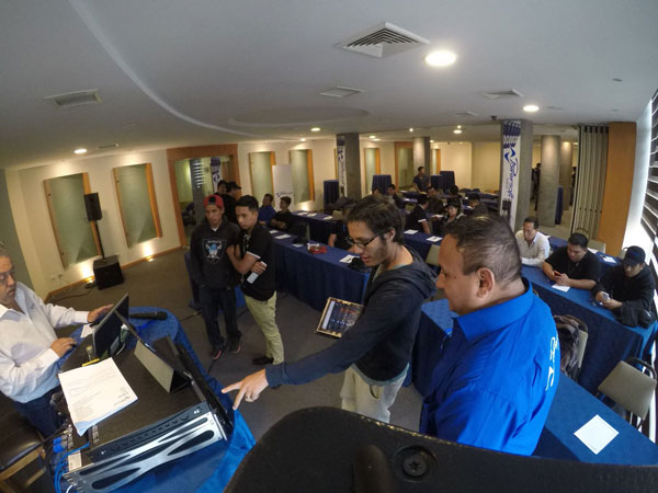 Attendees gather around a laptop and amplifier at the Powersoft product presentation in Quito