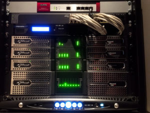 Rack with a network switch, a processor, four Powersoft install amplifiers and an X Series unit at the bottom