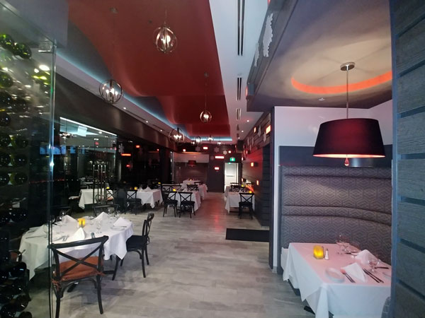 Ruth's Chris Steakhouse Toronto dining room with white tablecloths, red ceiling and pendant lamps