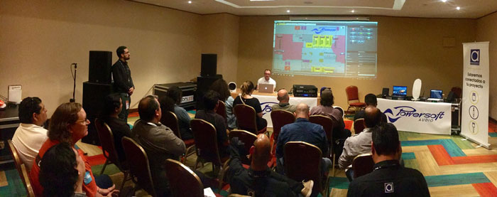 Powersoft demo room, wide view: seated audience facing a projected software screen