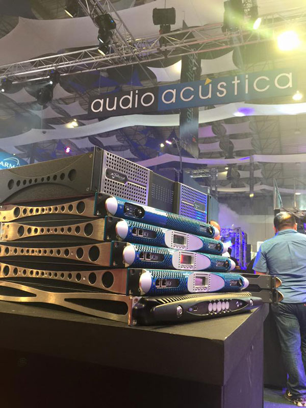 Stack of Powersoft Ottocanali, K Series and X Series amplifiers under the Audio Acústica banner at a trade show