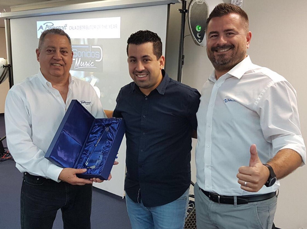 Three men with the Powersoft CALA Distributor of the Year award in its case; SuperSonidos logo on screen