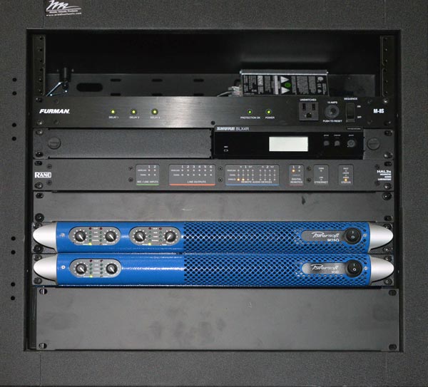 Rack con unità Furman, Shure e Rane sopra due amplificatori Powersoft M28Q