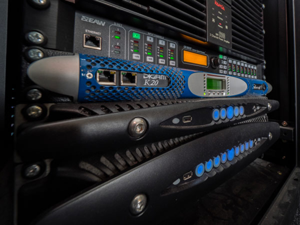 Rack with a Powersoft K20 amplifier above two X Series amplifiers and an EAW processor