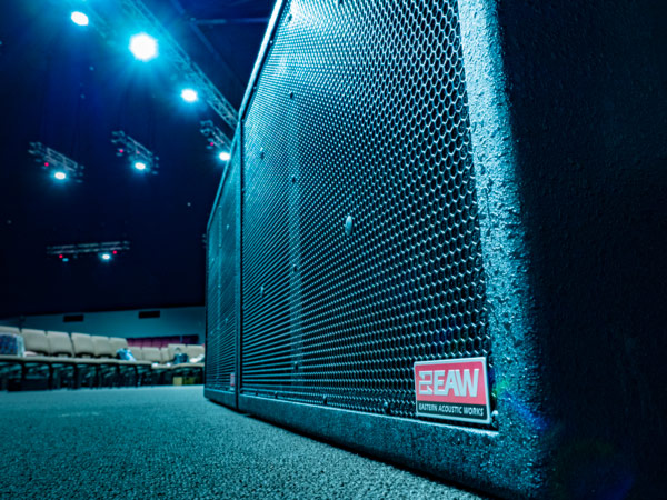 EAW loudspeaker on the floor of the WorshipCentre auditorium, with seating and stage lights behind
