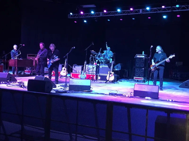 Five-piece band performing at Pompano Beach Amphitheater under blue and purple lights