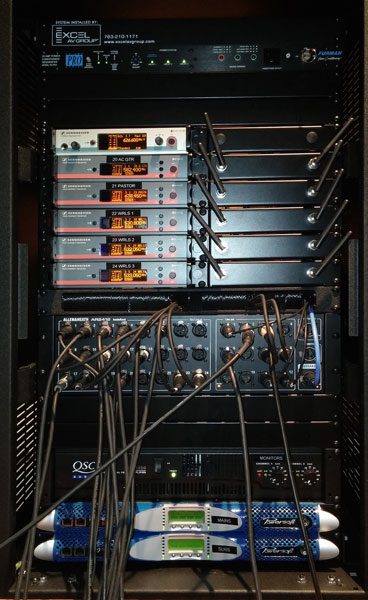 Rack with six Sennheiser wireless receivers, a stage box, a QSC amplifier and two Powersoft K Series amplifiers