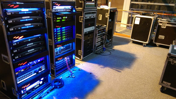 Touring rack cases with six Powersoft X8 amplifiers and signal processors, lit in blue