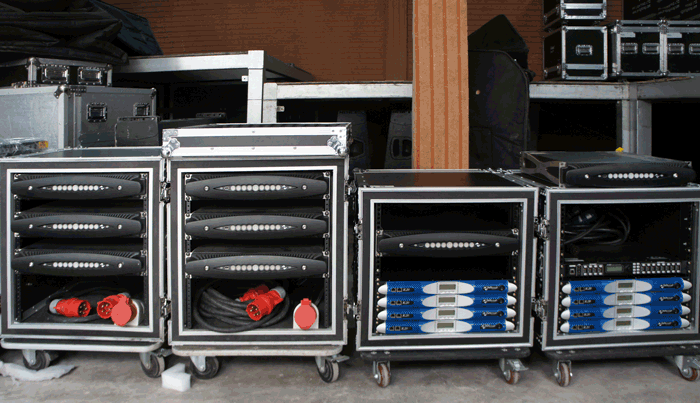 Rack cases on wheels with eight black Powersoft X8 amplifiers and blue K20 amplifiers