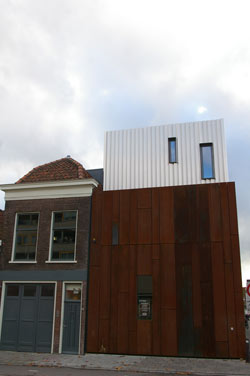 Exterior of the Nobel live venue in Leiden: rust-colored steel facade next to a brick house