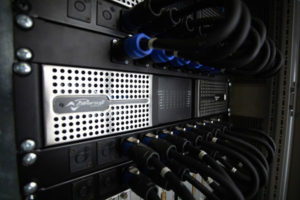 Powersoft amplifier in a rack, with speakON cables connected above and below