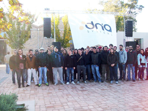 Seminar participants in a group photo in front of the DN'A Systems banner in Nafplio