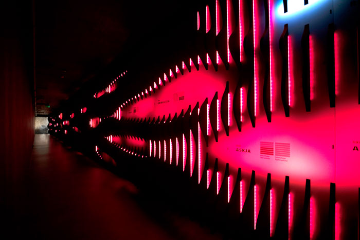 Dark corridor with a wall of red-lit fins and an Askja label