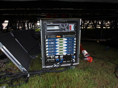 Rack of six Powersoft amplifiers with power distribution, on the grass under the Moomba Festival stage