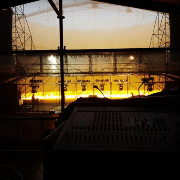View from the mixing console toward the stage and lighting rig during setup at Festival Provincia Emergente