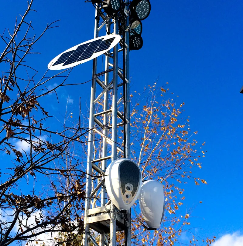 Two Powersoft Deva units and a solar panel mounted on a truss tower with lights