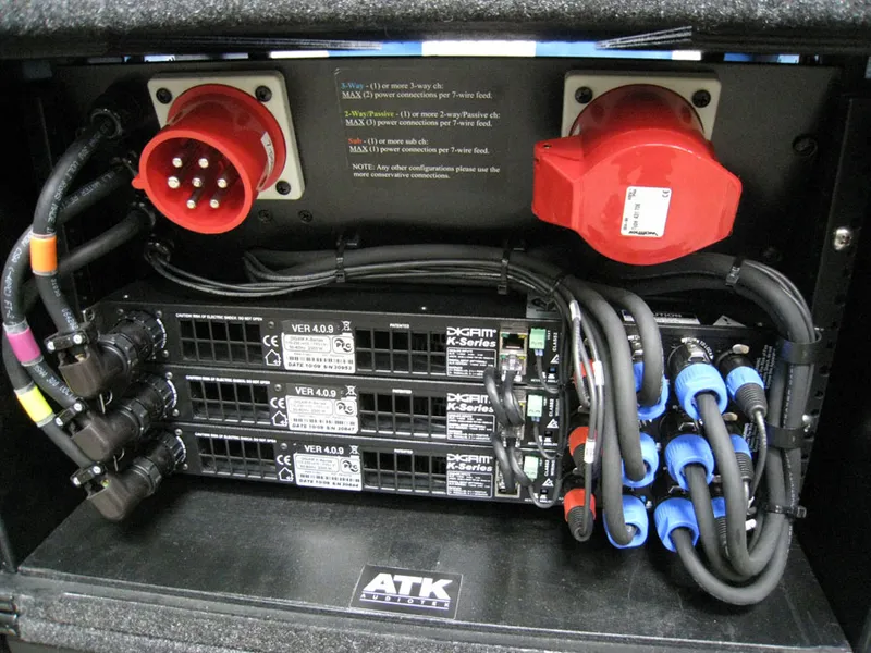 Rear of an ATK Audiotek amp rack: two red power connectors and three cabled DIGAM K Series amplifiers