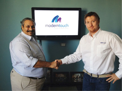 Handshake between Powersoft and Modern Touch representatives in front of the Modern Touch logo