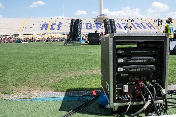 Flight case with three X8 amplifiers on the Artemio Franchi pitch, loudspeaker stacks behind