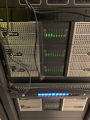 Rack di amplificatori Powersoft in funzione, con gli indicatori di livello verdi accesi